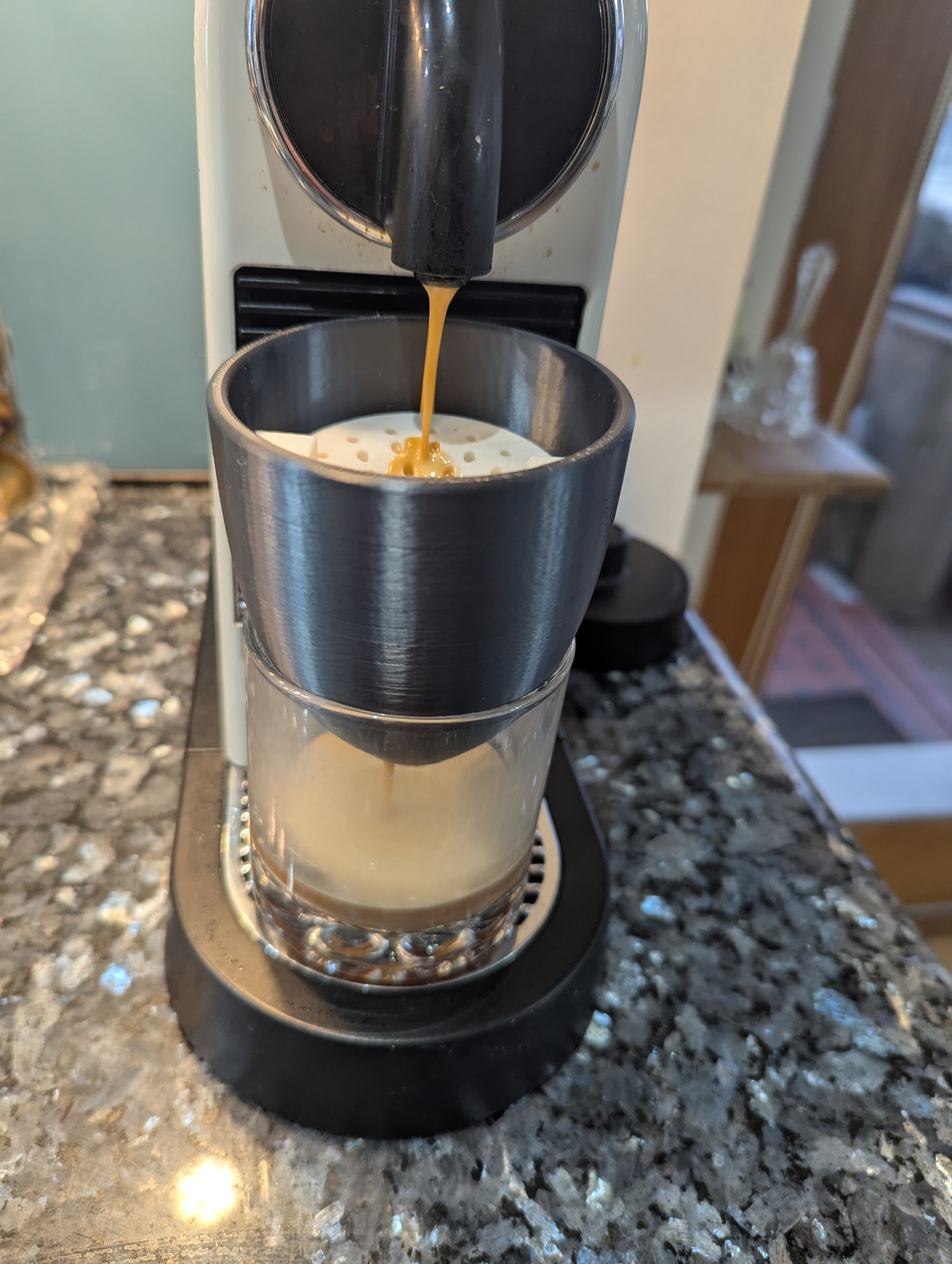 Complete espresso chilling setup showing espresso machine at top and glass at bottom collecting chilled espresso